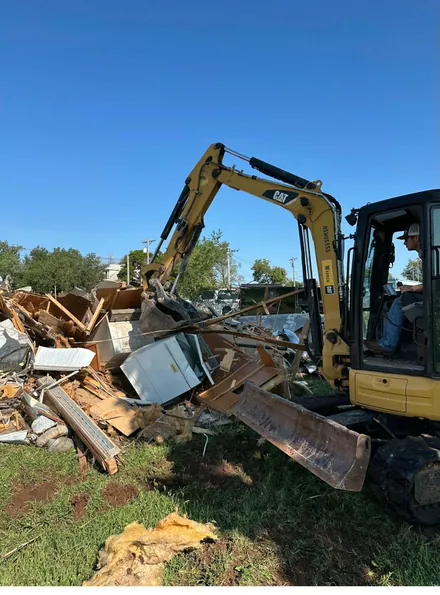Excavator clearing debris on an Oklahoma job site