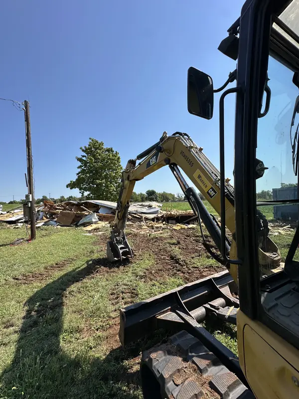 CAT excavator working through mobile home debris