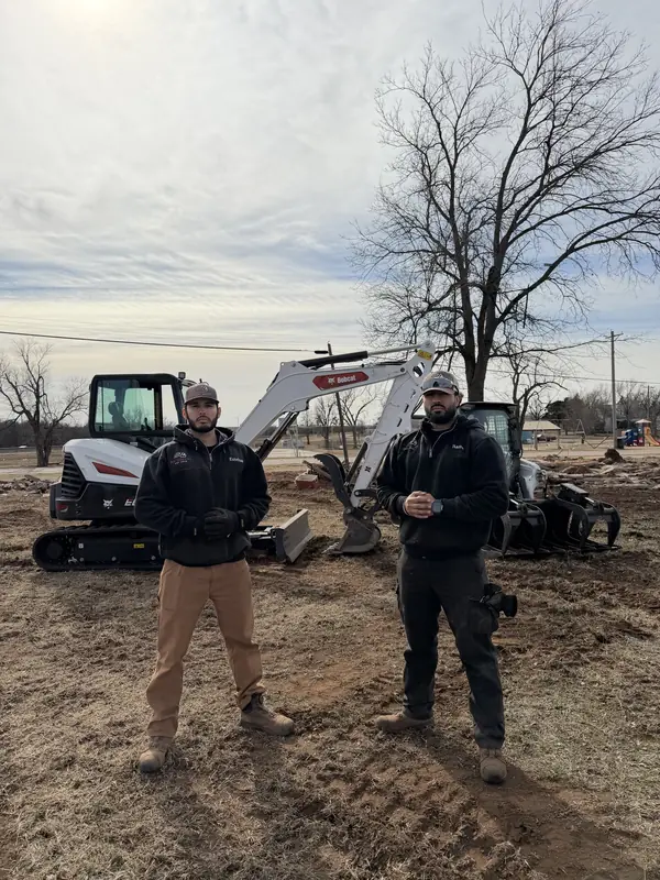 Crew posed with Bobcat E60 — cleared site OKC