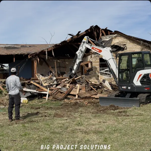 CAT excavator working a concrete debris pile