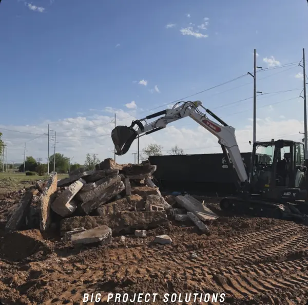 House teardown — Bobcat on debris mid-demo
