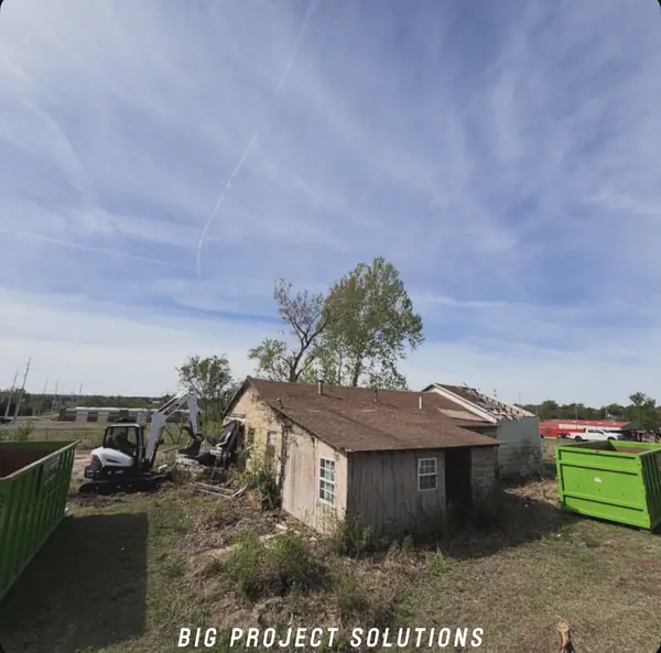 Cleared lot with green & black roll-offs on site