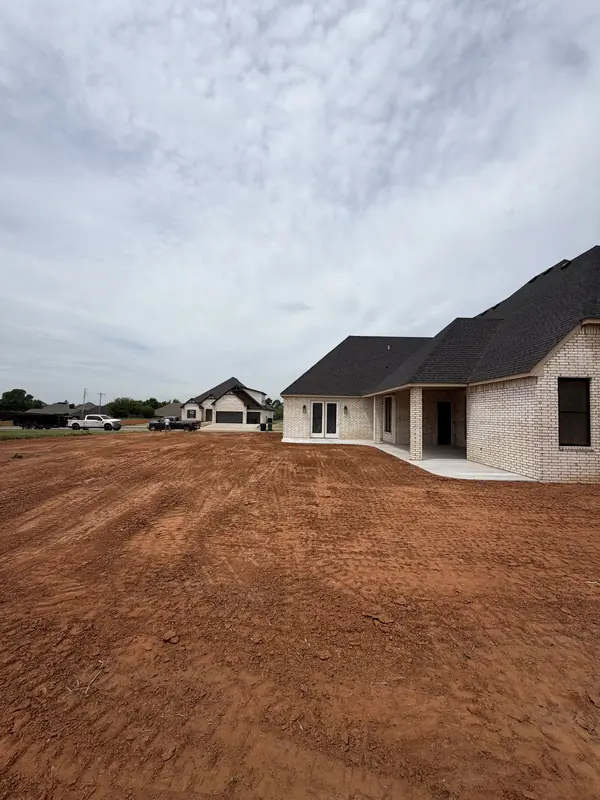 Graded lot beside new brick home — site work complete